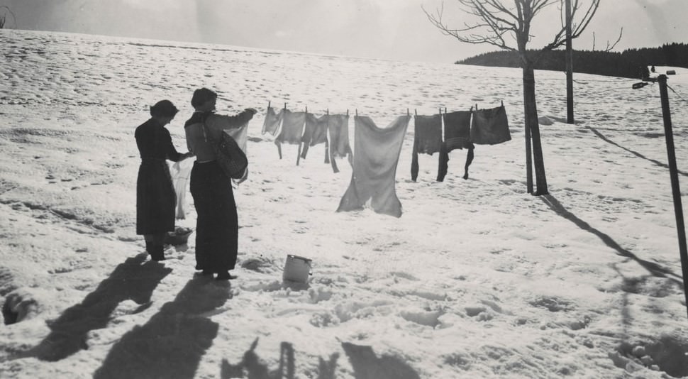 Women hanging laundry in the snow.