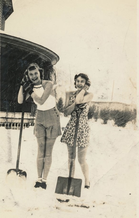 Young women in skirts digging snow.