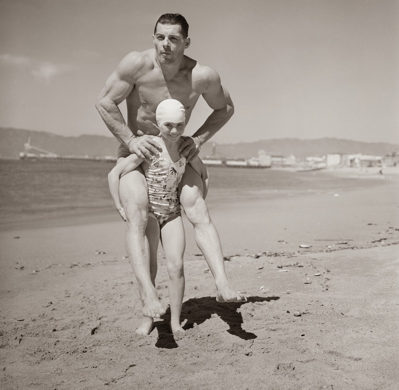 March 29, 1940. Patricia O’Keefe, who weighs only sixty-four pounds, holds two-hundred-pound Wayne Long on her back in an unusual exhibition of strength.