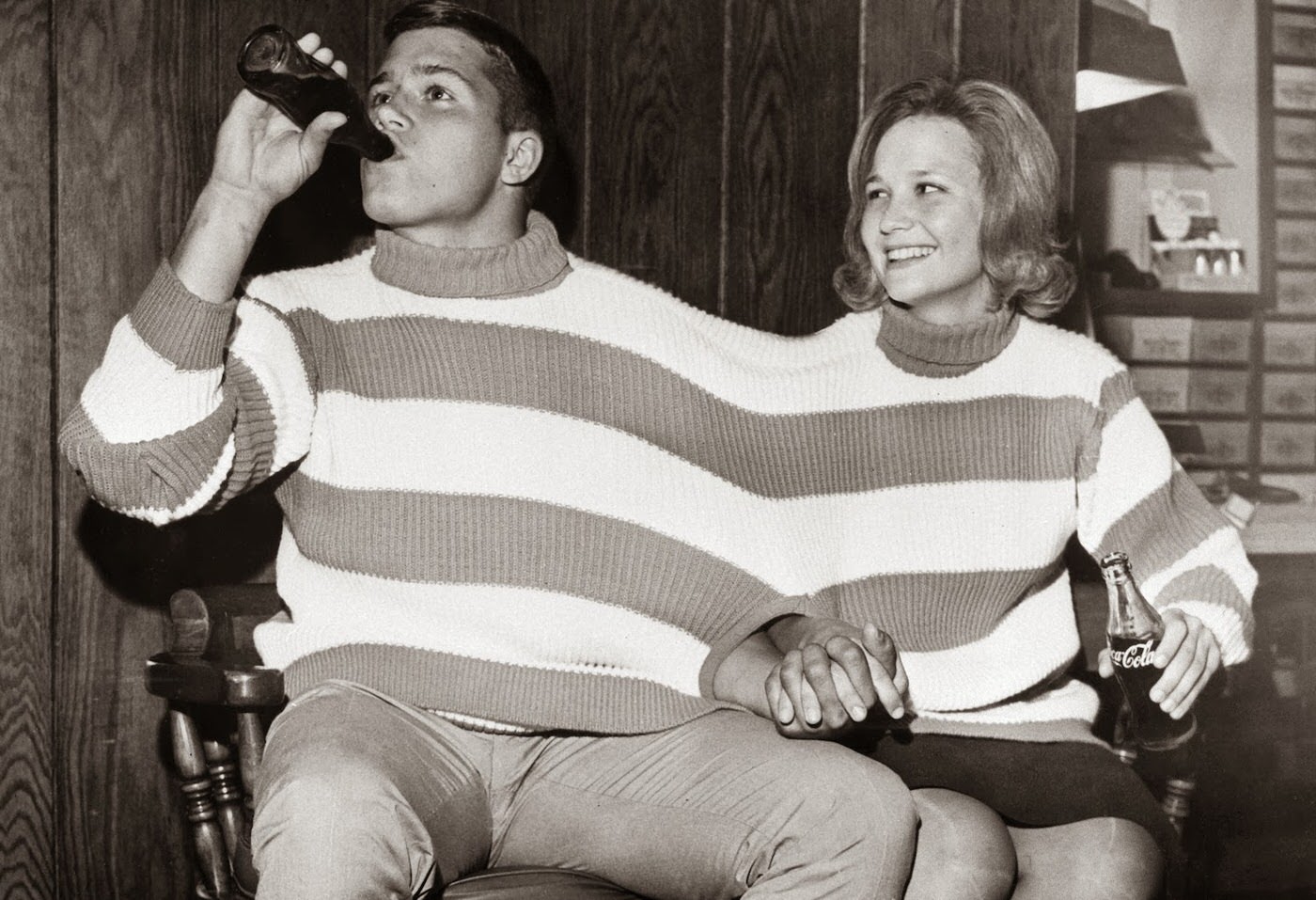 October 17, 1963. Tommy Harper and Chica Gray share a sweater built for two in a local downtown shop. The Tweter is the newest fad to sweep the country. With two sleeves, two turtlenecks, and one center armhole, it carries togetherness to the ultimate extreme.