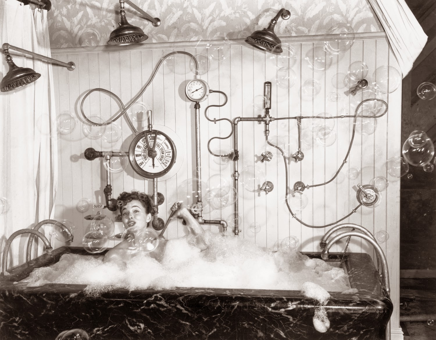 August 4, 1949. Ann Blyth, film star, taking a bubble bath here with an assortment of gadgets at hand.