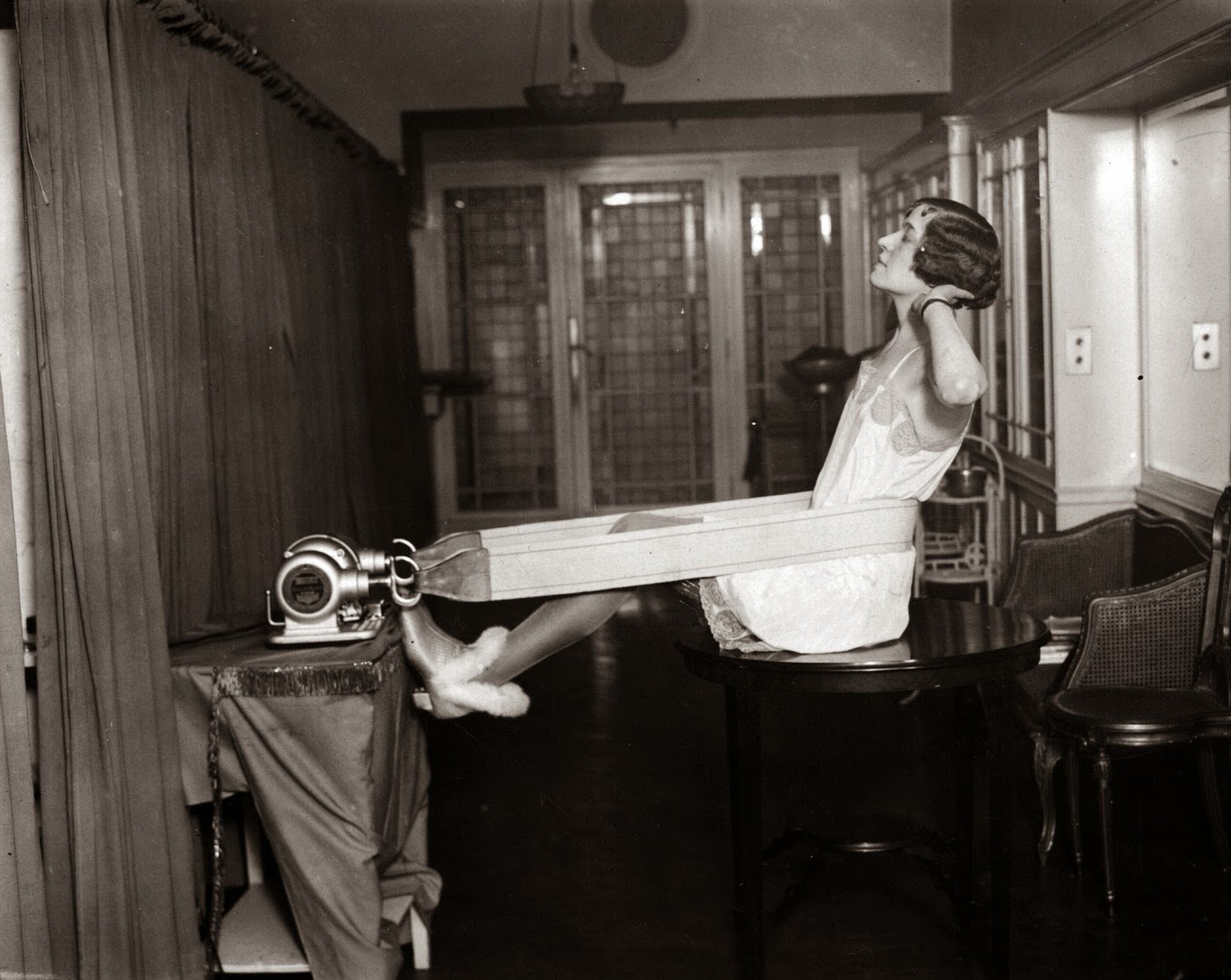 A woman exercising on a vibrating motor machine, 1928.