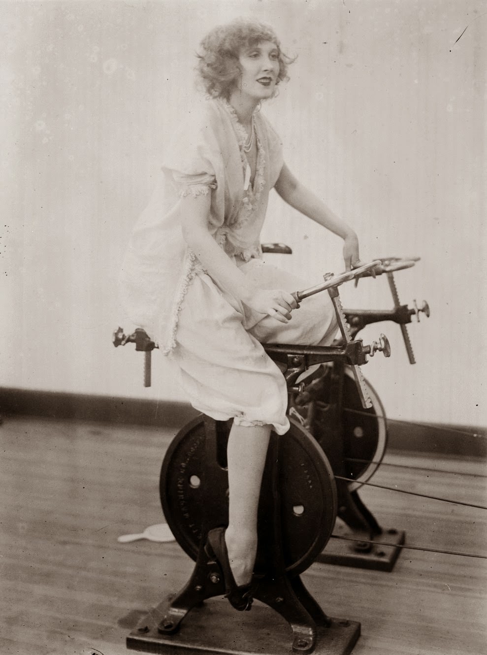 A woman using a stationary cycle, 1921.