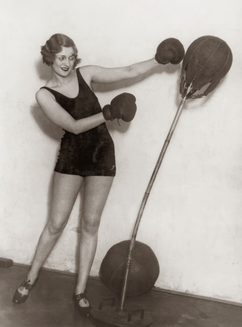 A young lady in a leotard directs her energies at a punchbag, circa 1925.