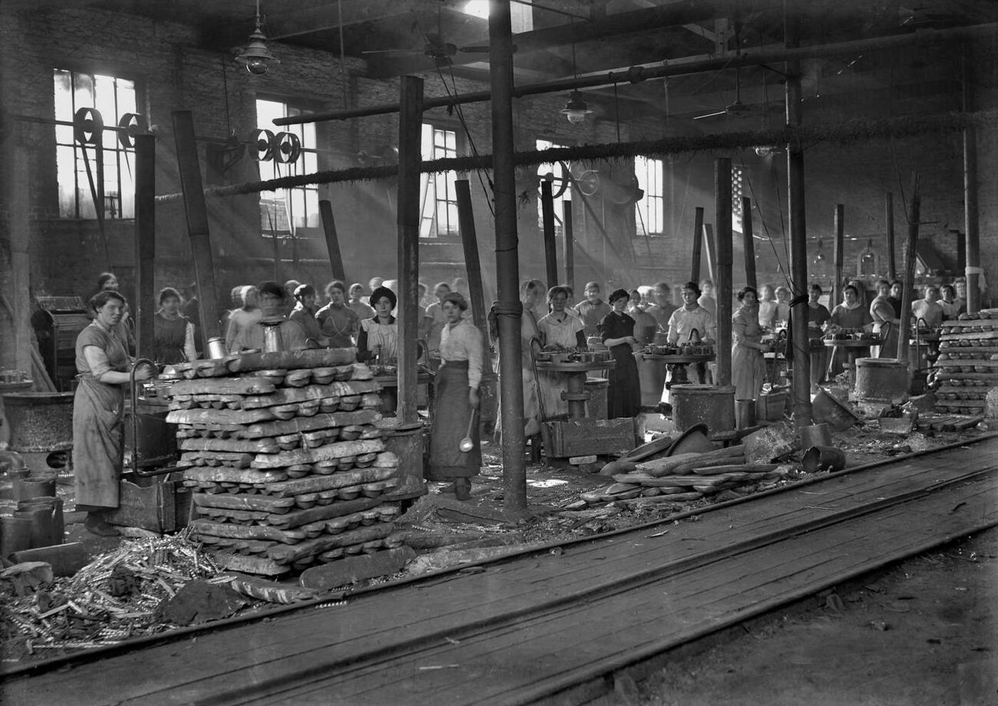 A large group of female manual workers in a factory producing lead shrapnel for use in high explosive artillery shells, WW1.