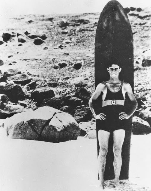 Surfer posing with his surfboard, ca. 1935