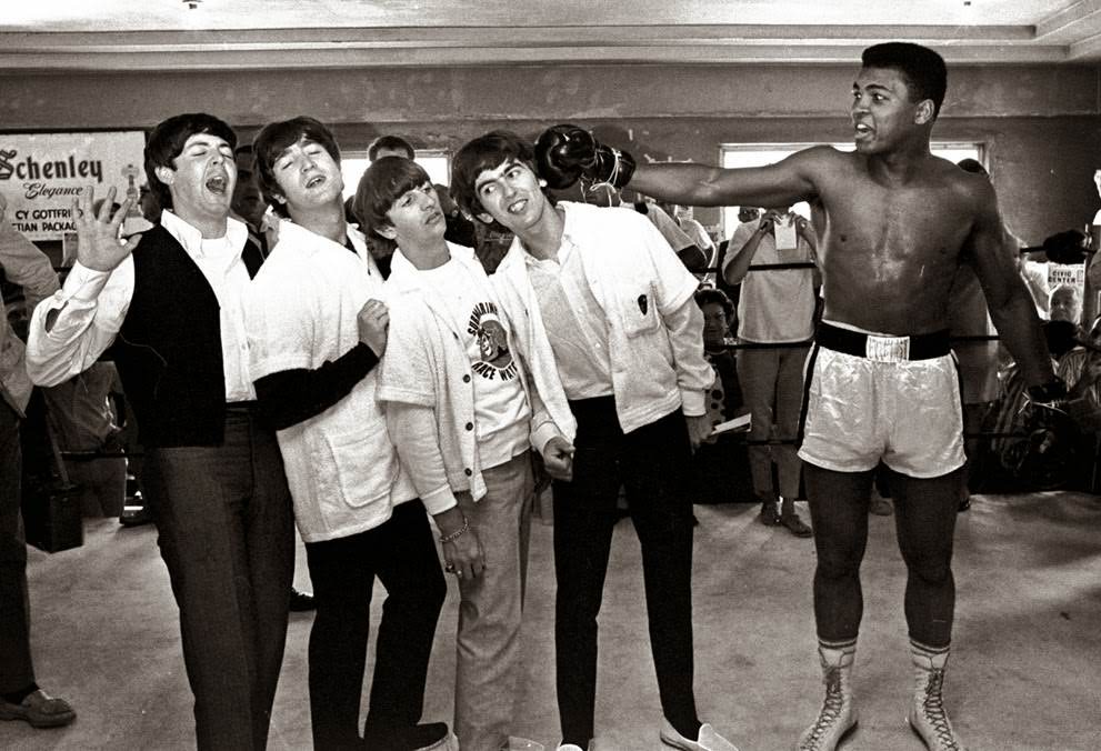 The Beatles take a fake blow from Cassius Clay, who later changed his name to Muhammad Ali, while visiting the heavyweight contender at his training camp in Miami Beach, Florida, 1964.