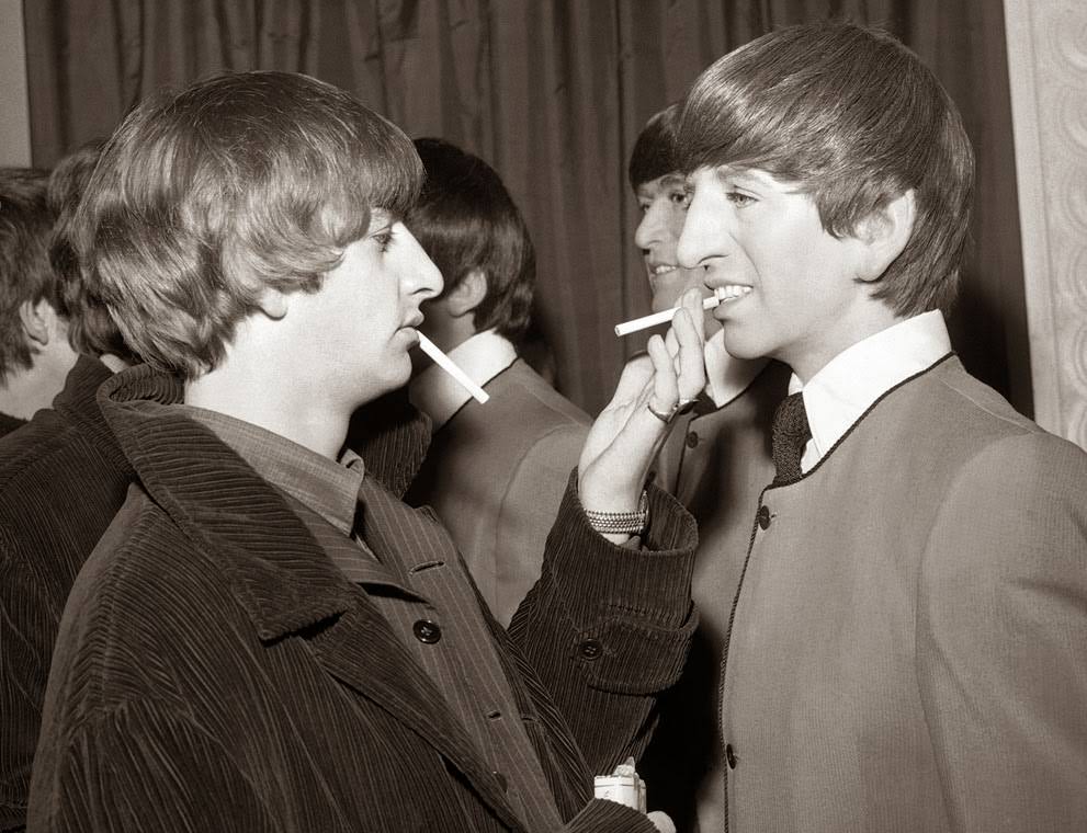 Beatle drummer Ringo Starr eases the pain on a wax likeness of himself with a cigarette, during the unveiling ceremony for four wax models of the Beatles at Madame Tussaud's Waxworks, in London, 1964.