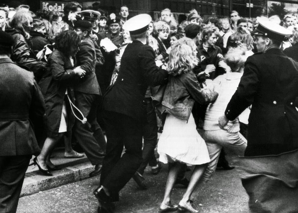 4,000 Beatles fans gathered in the streets around the Royal Hotel in Copenhagen, Denmark, several hours before the British pop group arrived; Danish police try to hold back the fans from rushing the hotel, 1964.