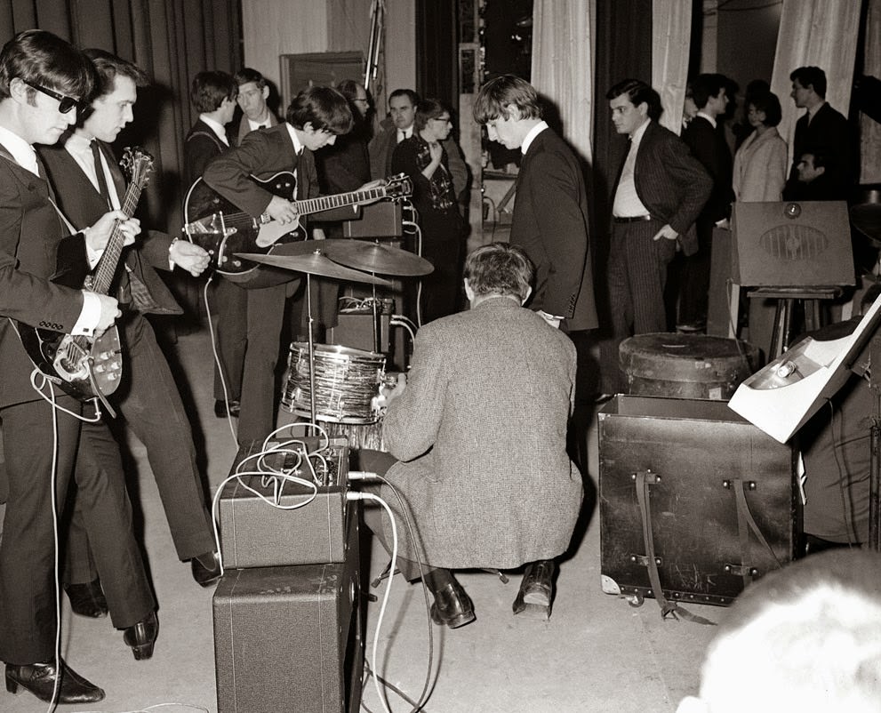 John Lennon, George Harrison, and Ringo Starr from the Beatles, backstage in Versailles, France, 1964.
