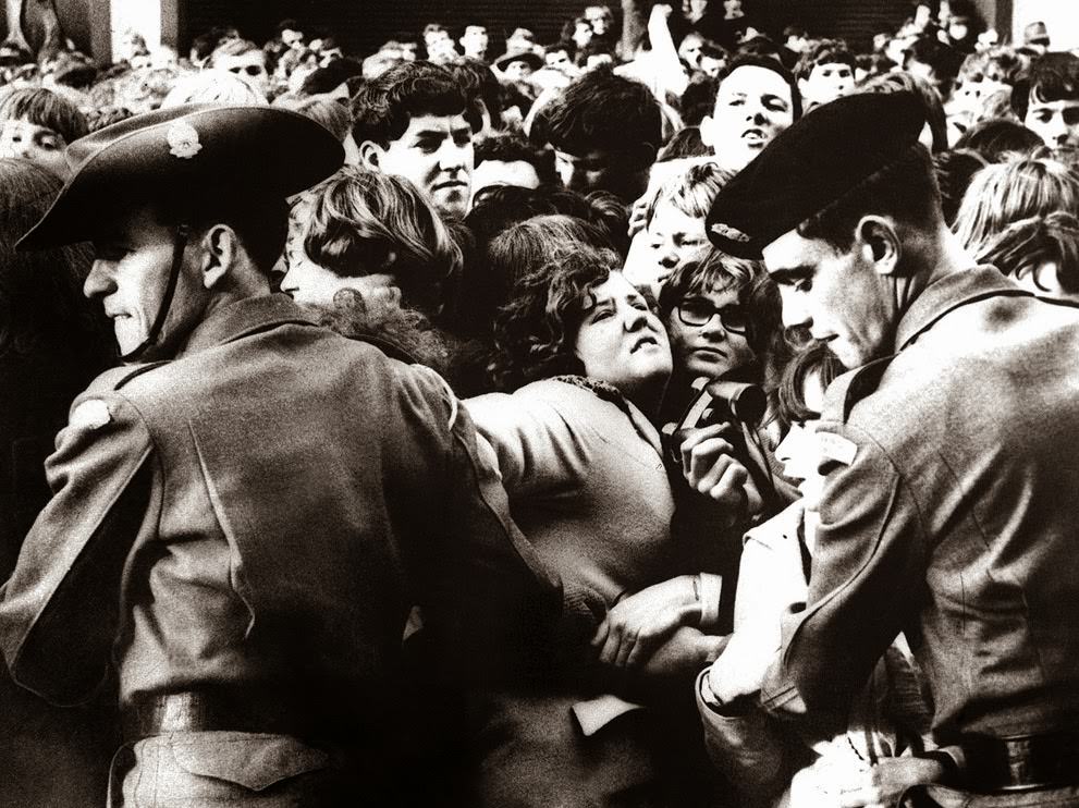 Two Australian soldiers link arms to control a section of the crowd outside the Southern Cross Hotel in Melbourne on the arrival of the Beatles; some 300 policemen and 100 soldiers made an attempt to contain 10,000 screaming fans, 1964.