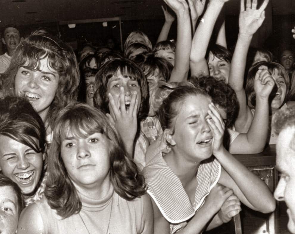 Just the sight of The Beatles from a distance caused this reaction among a group of girls at the Los Angeles International Airport; airport security kept several thousand youngsters away from the British singers during a brief stopover in Los Angeles en route to San Francisco, 1964.