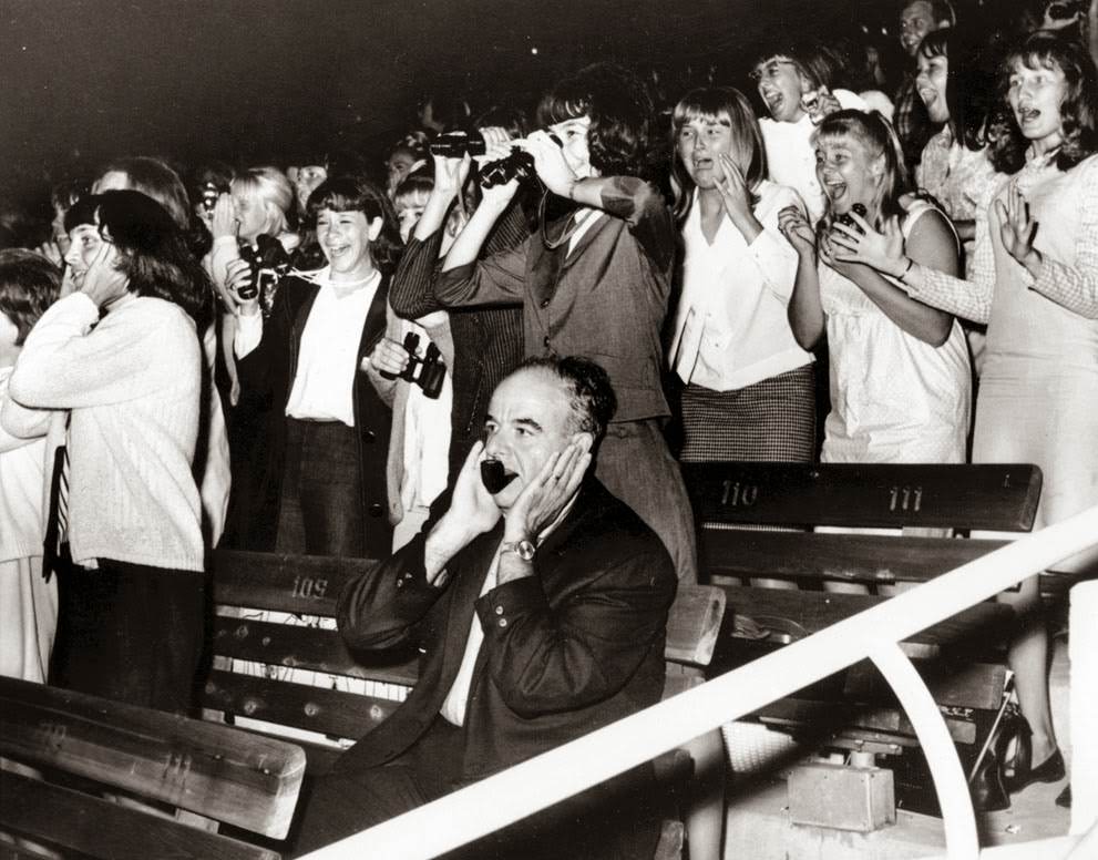 A man covers his ears as 18,000 screaming fans react to The Beatles in the Hollywood Bowl, California, during their U.S. concert tour, 1964.