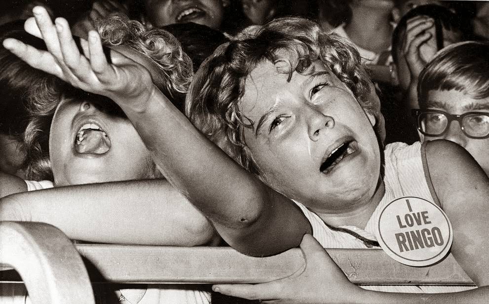 A tearful Beatle lover pleads unsuccessfully with a policeman to carry her fan button to Ringo Starr at two Indiana State Fair shows in Indianapolis, 1964.