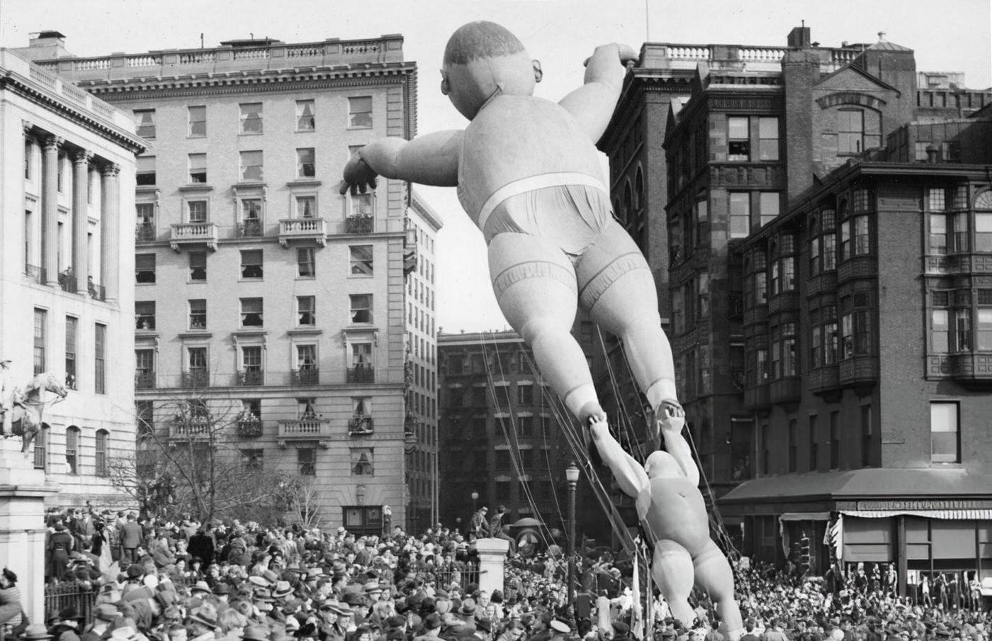 Acrobat balloons float past the Massachusetts State House during the annual Santason parade in Boston, 1941.