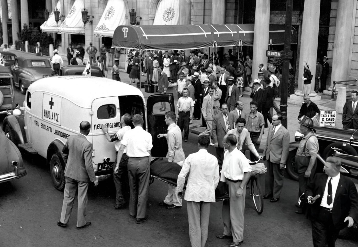 A person posing as a victim during an air raid drill is placed in an ambulance at Copley Square in Boston, 1942.