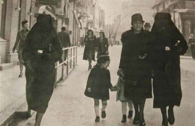 A Muslim woman covers the yellow star of her Jewish neighbor with her veil to protect her from prosecution in Sarajevo, 1941.