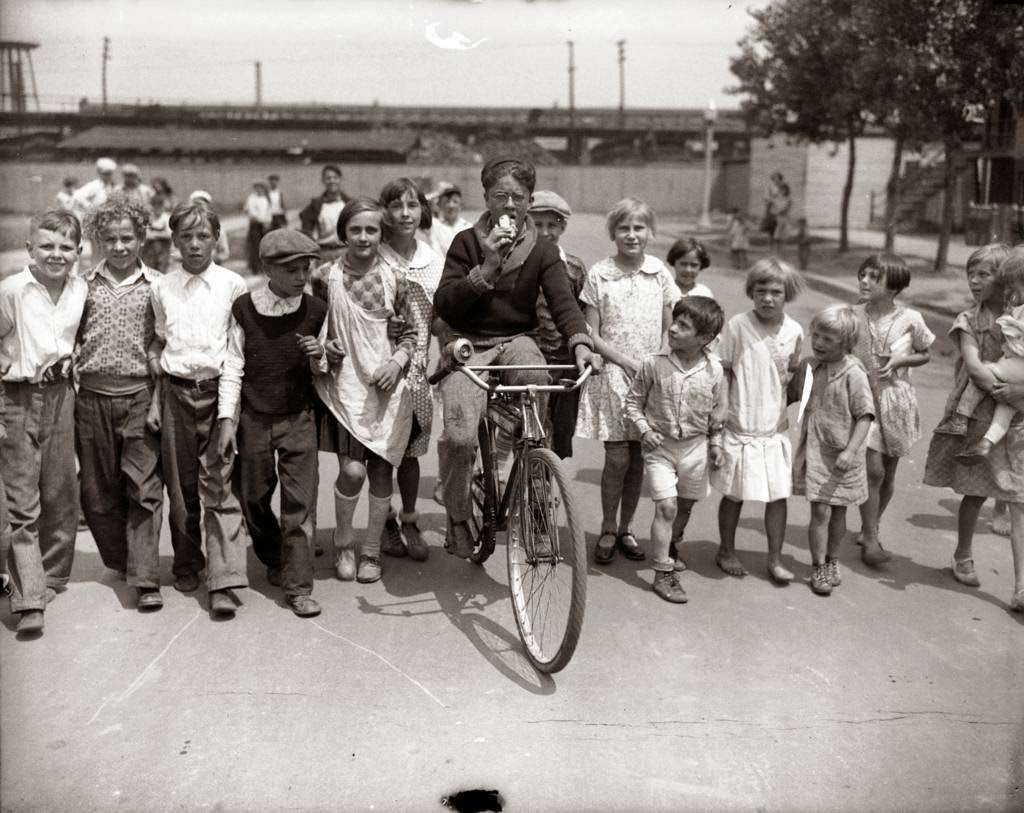 Endurance bicyclist Victor Preisinger is pedaling until his bike wears out, while eating an ice cream cone from a fan, 1930.