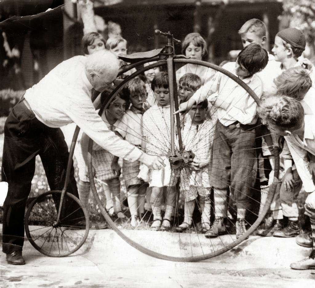Hubert K. Oram, of the Austin neighborhood, with his old-fashioned bike that has pedals mounted on the huge front wheel, 1928.
