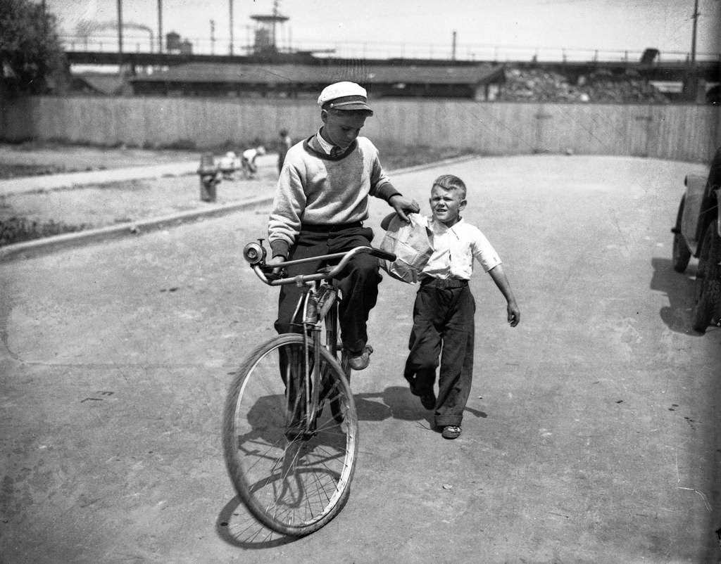 Edward Schmidt hands endurance bike rider George Hoffman a paper bag in Chicago, 1930.