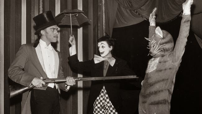 A scene from 'The Circus Adventure' at the Arts Theatre; Douglas Dempster as the wicked ringmaster holds up the talking cat played by Ursula Jones watched by Pinky the clown played by Matyelok Gibbs.