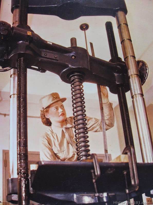 A WAC, in training at a WAC training center, checks the registration scale of a testing machine.