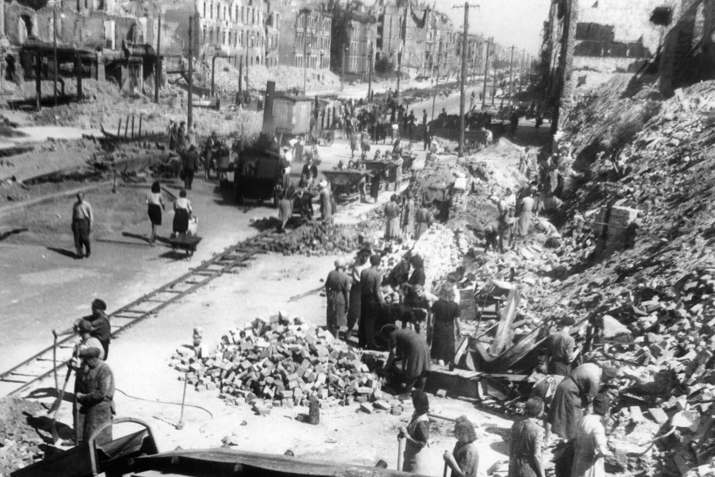 Women and men are pictured clearing the ruins in Berlin, 1945.