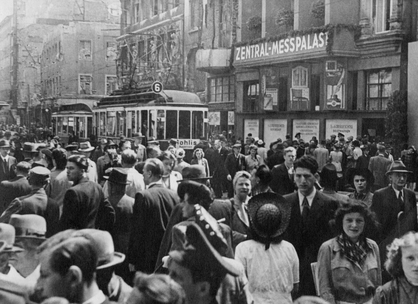 Traffic on Grimmaische Strasse Street during the Autumn Fair in Leipzig; in the background is the Zentral-Messpalast, 1946.