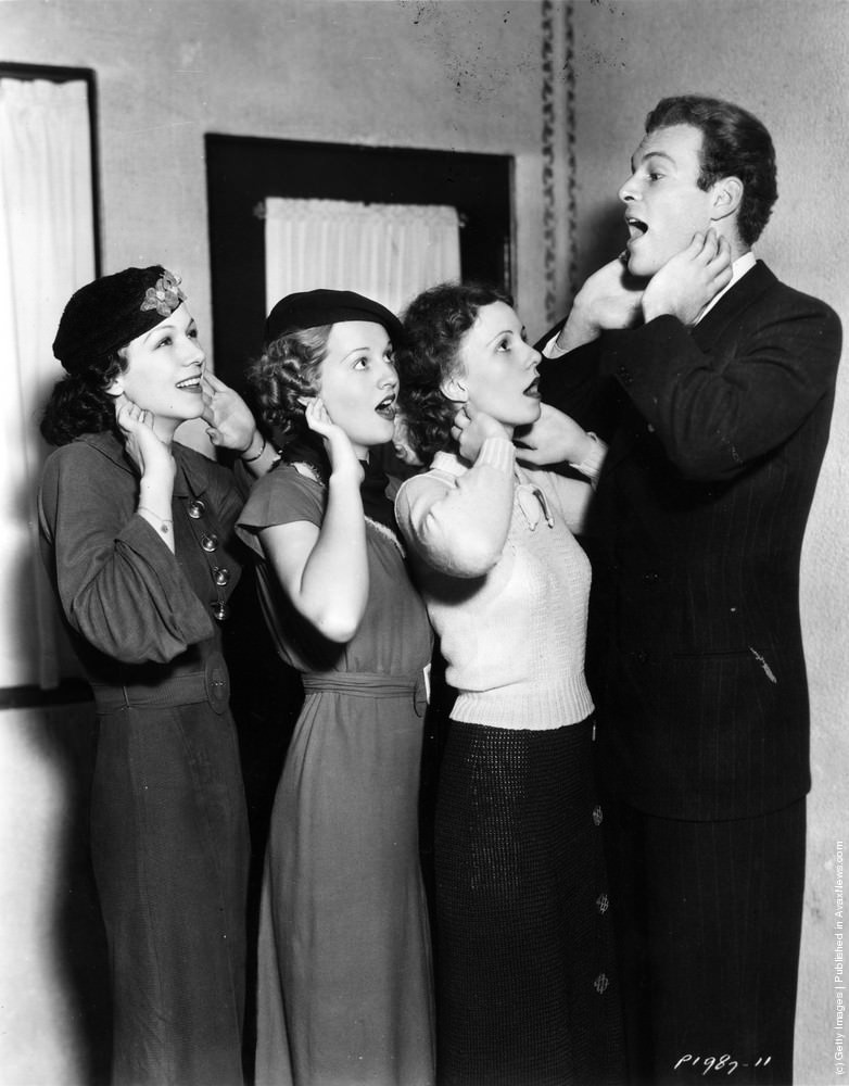 Glenn Erikson teaching Paramount actresses Kay Gordon, Jane Rhodes and Jeanne Perkins how to relax their throats for improved voice control, 1936.