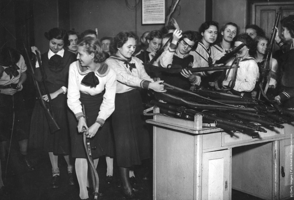 Military training has been introduced to the schools in Budapest; here the pupils of a girl's school are issued with their arms, 1939.