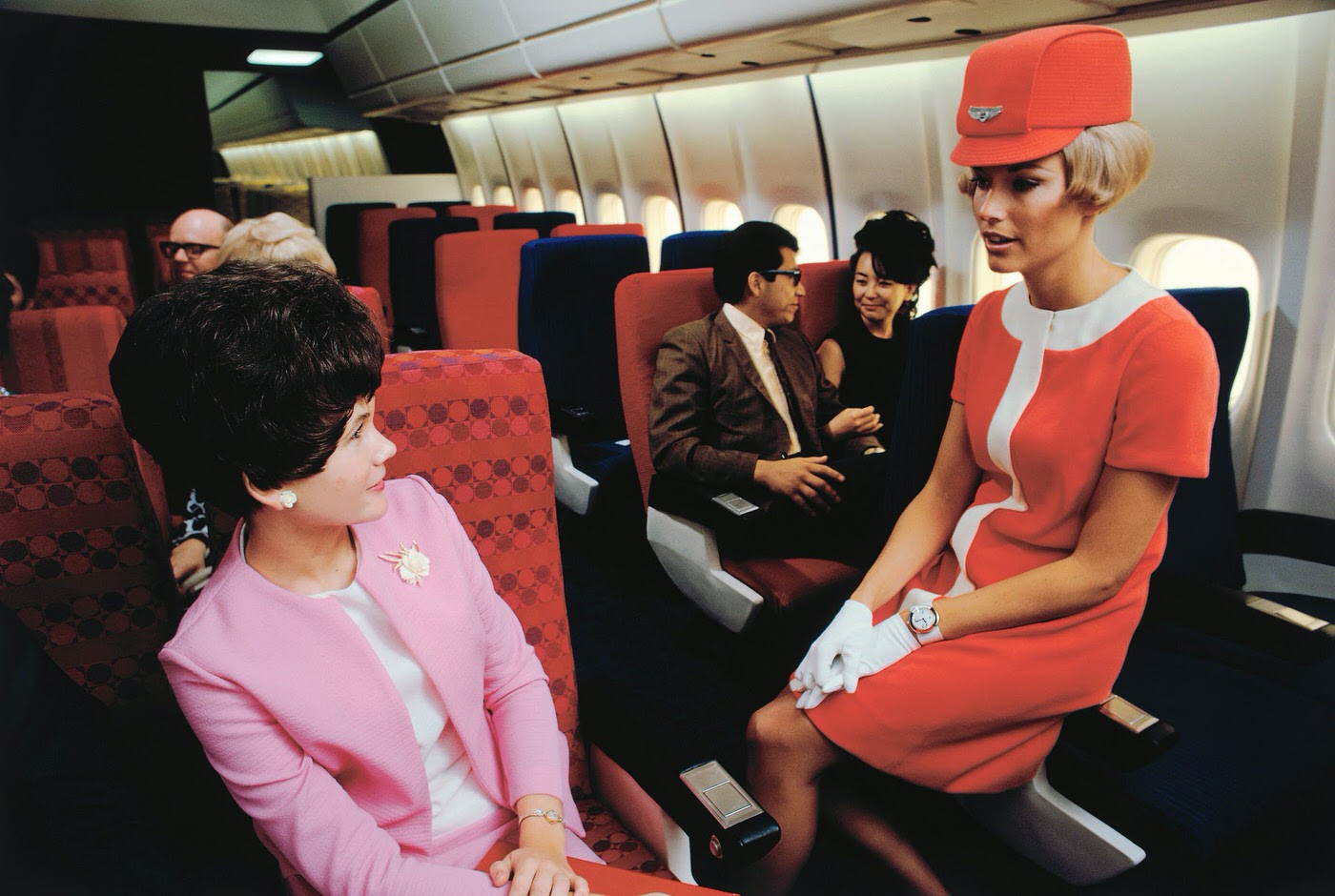 A United Airlines stewardess chats to a passenger in a simulated cabin of a Douglas DC-10, 1968.