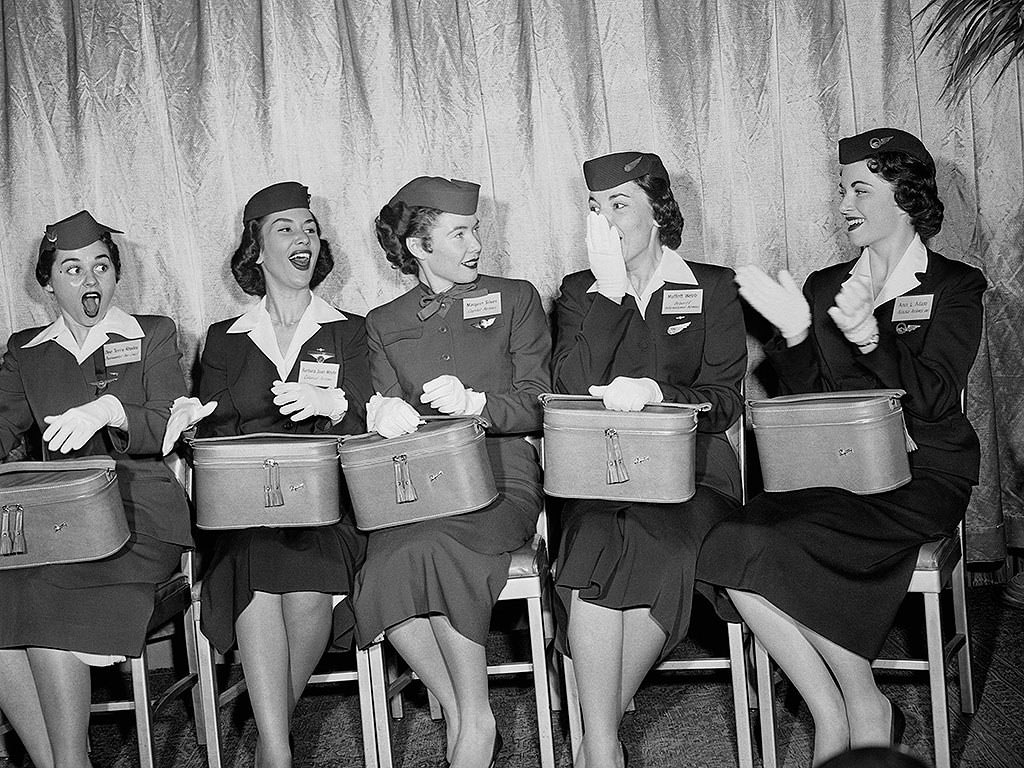 In the ’50s, flight attendants donned crisp collars and white gloves, with perfect coifs under their caps, 1956.