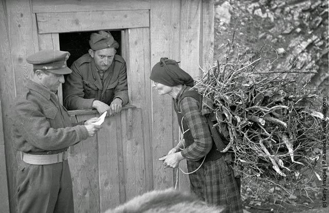 A Greek woman checks in with the village patrol for the evening curfew during the Greek Civil War, 1948.
