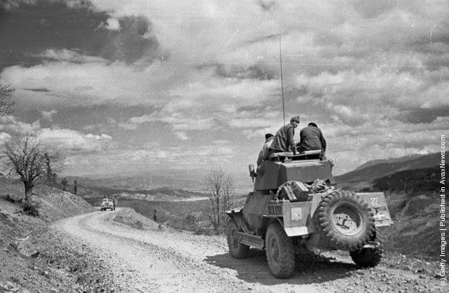 A truck carries a band of government soldiers along a rocky mountain pass during the Greek Civil War, 1948.