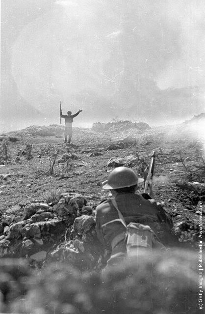 One exhausted guerrilla fighter surrenders to the Greek army during the Greek Civil War, 1948.