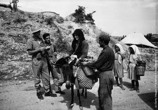 Greek regular soldiers search a peasant and his wife for arms, which are being smuggled to the Andartes rebels during the Greek Civil War, 1947.