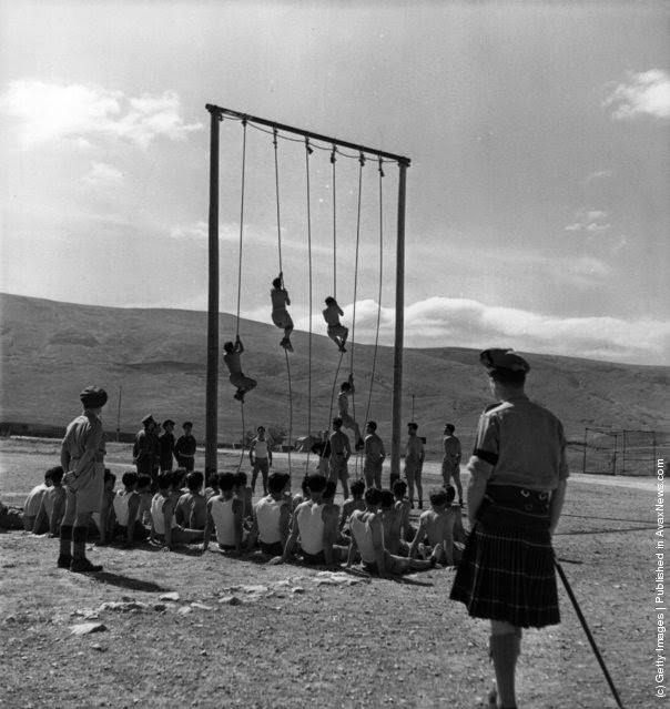 Greek soldiers climbing ropes during training by British officers in the Greek civil war, 1947.