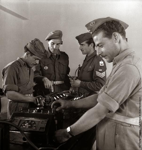 A class of recruits in the technical training wing of a Greek training centre are given advice from a British instructor during the civil war, 1947.