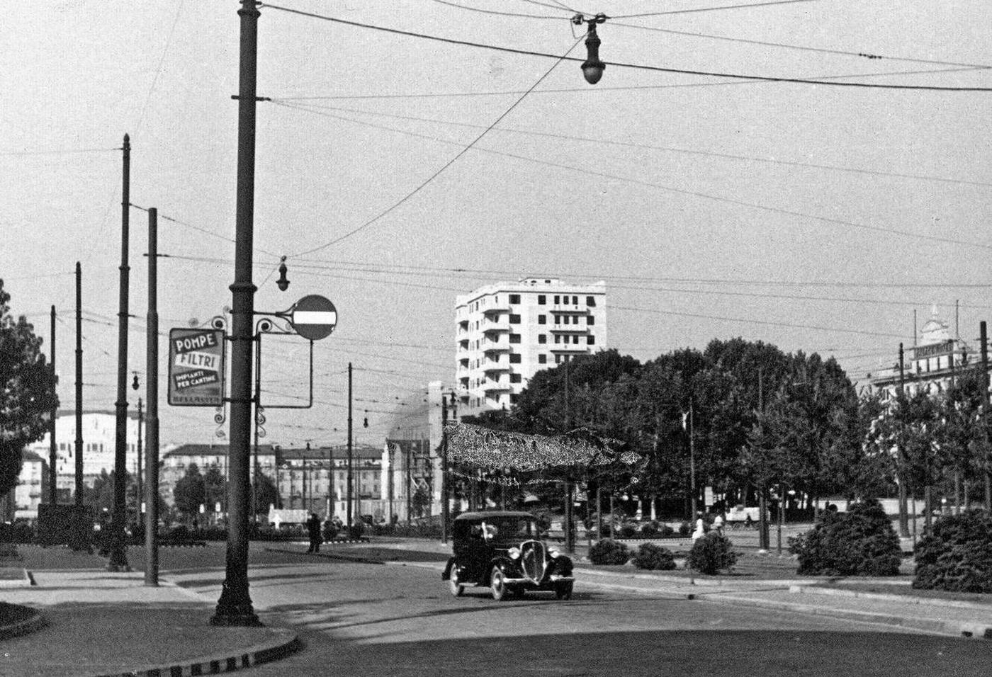 Car driving down street in Milan Italy, 1930s.