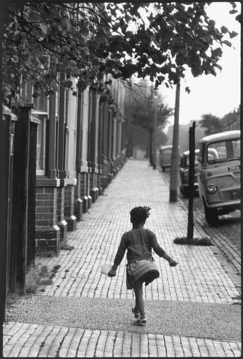 Child skips along a street in Brixton, South London.