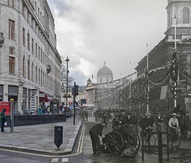 A view of Duncannon Street decorated with bunting and banners for the coronation ceremony of Edward VII. There are pedestrians and vehicles in the foreground and the National Gallery is visible in the distance in 1902 and 2014.
