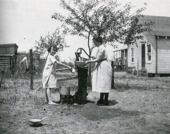 Catherine Rehbein helping her daughter get a drink from the well in Union Beach.