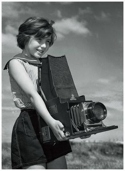 Maxine Sullivan, age 10, with her father's large Graflex camera, at the beach of 1950's Melbourne, Australia.