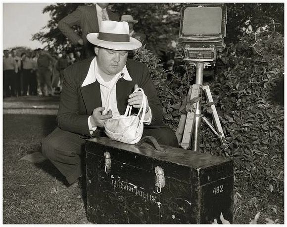 Detective Patrick O'Brien of the Chicago Police Crime Lab, records a major crime scene with his large format Ansco camera in June, 1950.