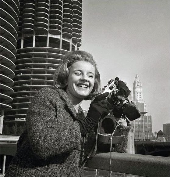Roberta Woolley, an English actress visiting Chicago, Illinois in March 1964, sports a 35mm Corfield Periflex camera and a Weston Master light meter.