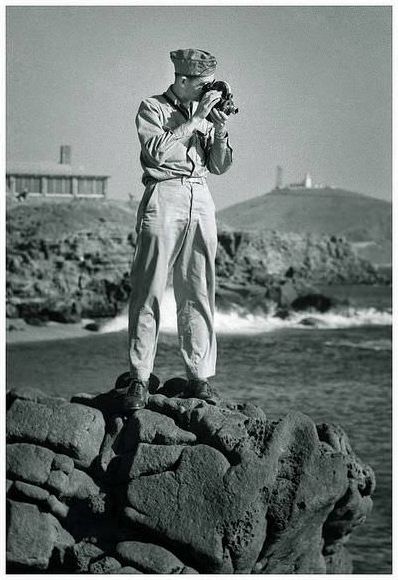 United States serviceman with a Bell & Howell Eyemo movie camera.