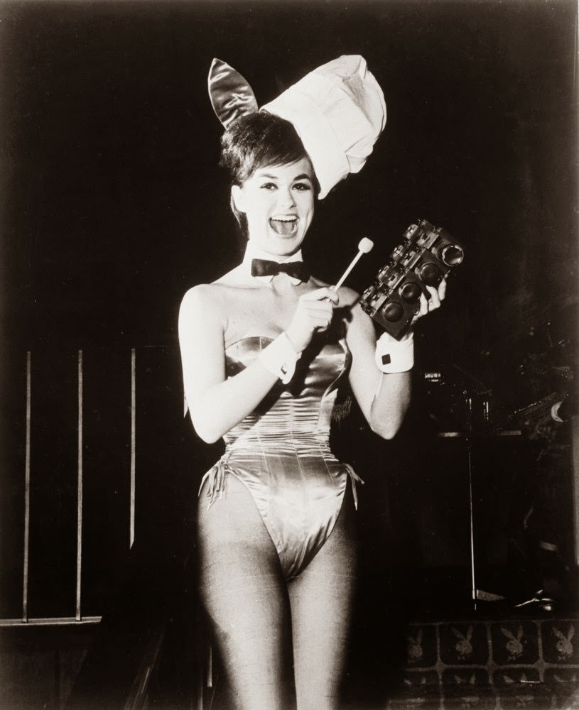 Glamorous 'Bunny Girl' Wanda rings a gong for breakfast at Hugh Hefner's 'Playboy Club', 1962.