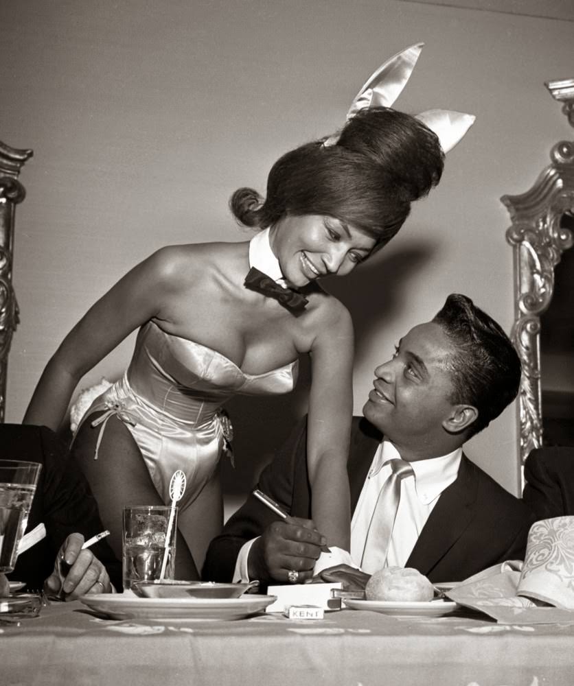 Rock and roll singer Jackie Wilson autographs the cuff of a Playboy Bunny at a dinner for the Motion Picture Pioneers Association at the Playboy Club in New York, 1962.