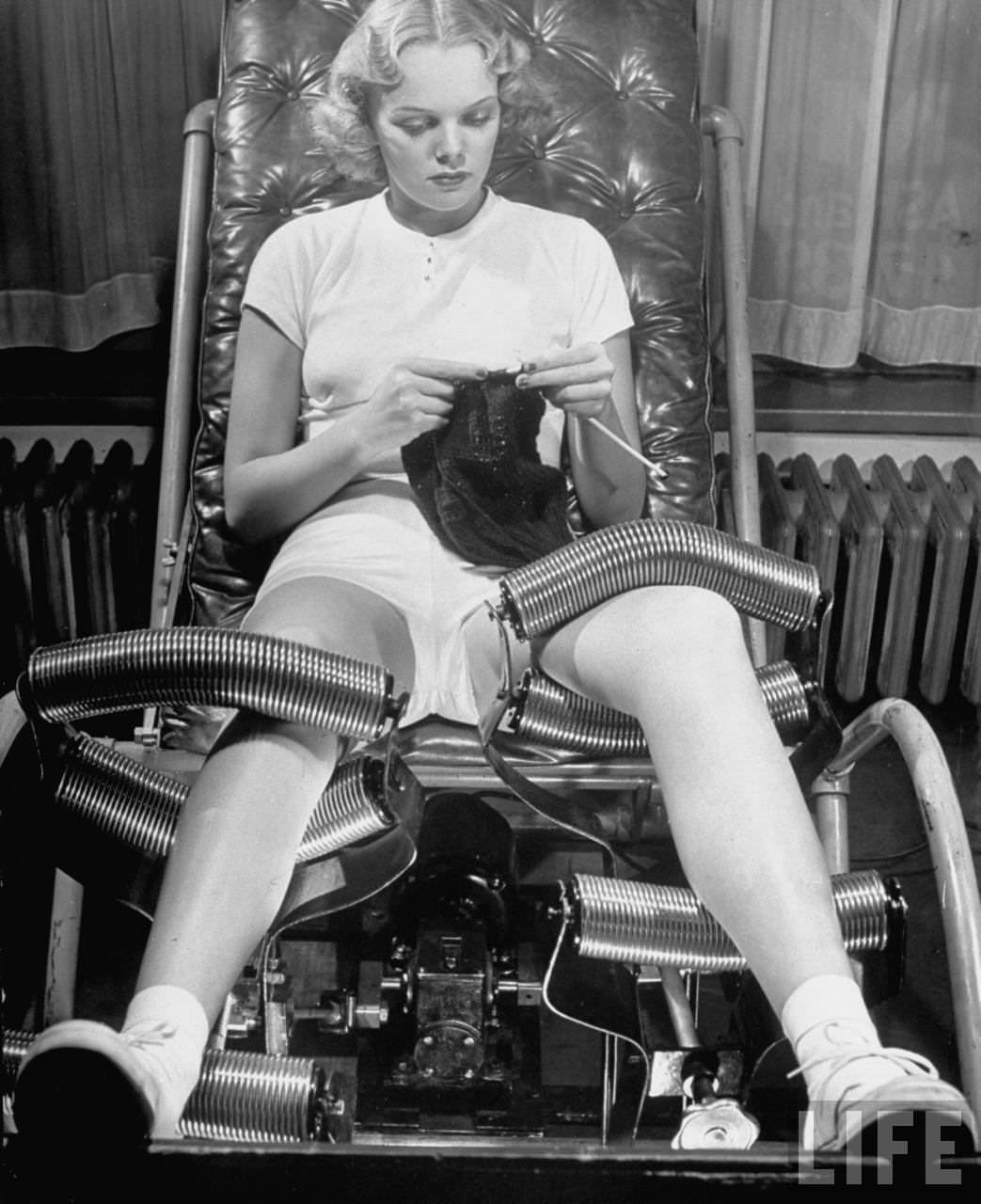Model Pat Ogden at slenderizing salon knitting in padded chair while leg rollers work from thigh to ankle.