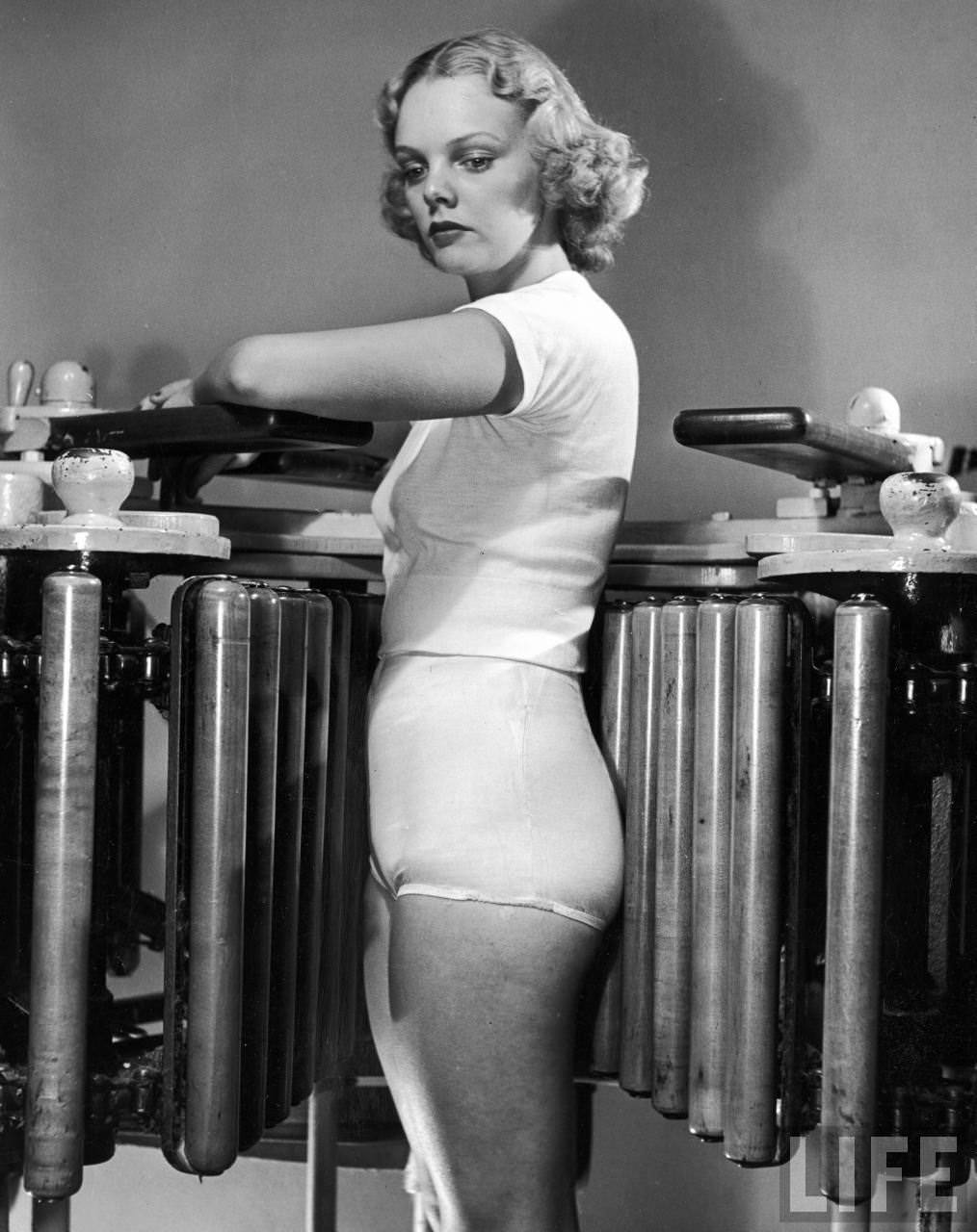 Model Pat Ogden at slenderizing salon using Wooden Barrel Massager to reduce hips and buttocks.